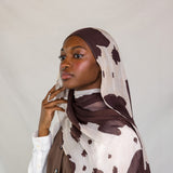 Model close-up showing the different types of brown spots on cream base of the Prairie Hide scarf.