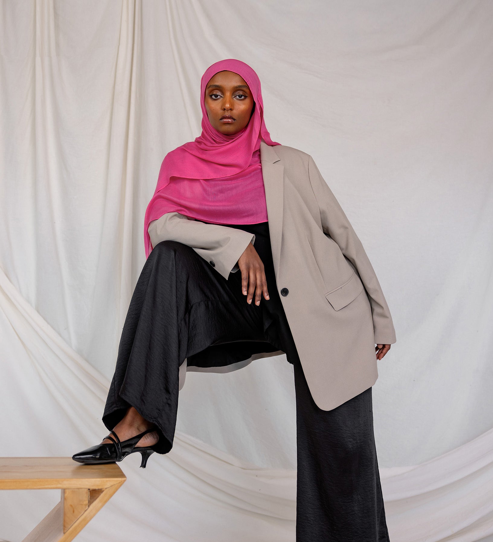 Model shown styled in Rose Wave, a vibrant pink solid scarf.