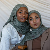 Two girls modeling in a green toned paisley printed hijab.