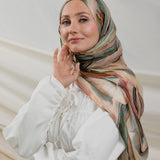 Model wearing modal hijab with a layered sediment-inspired print and artistic detailing.