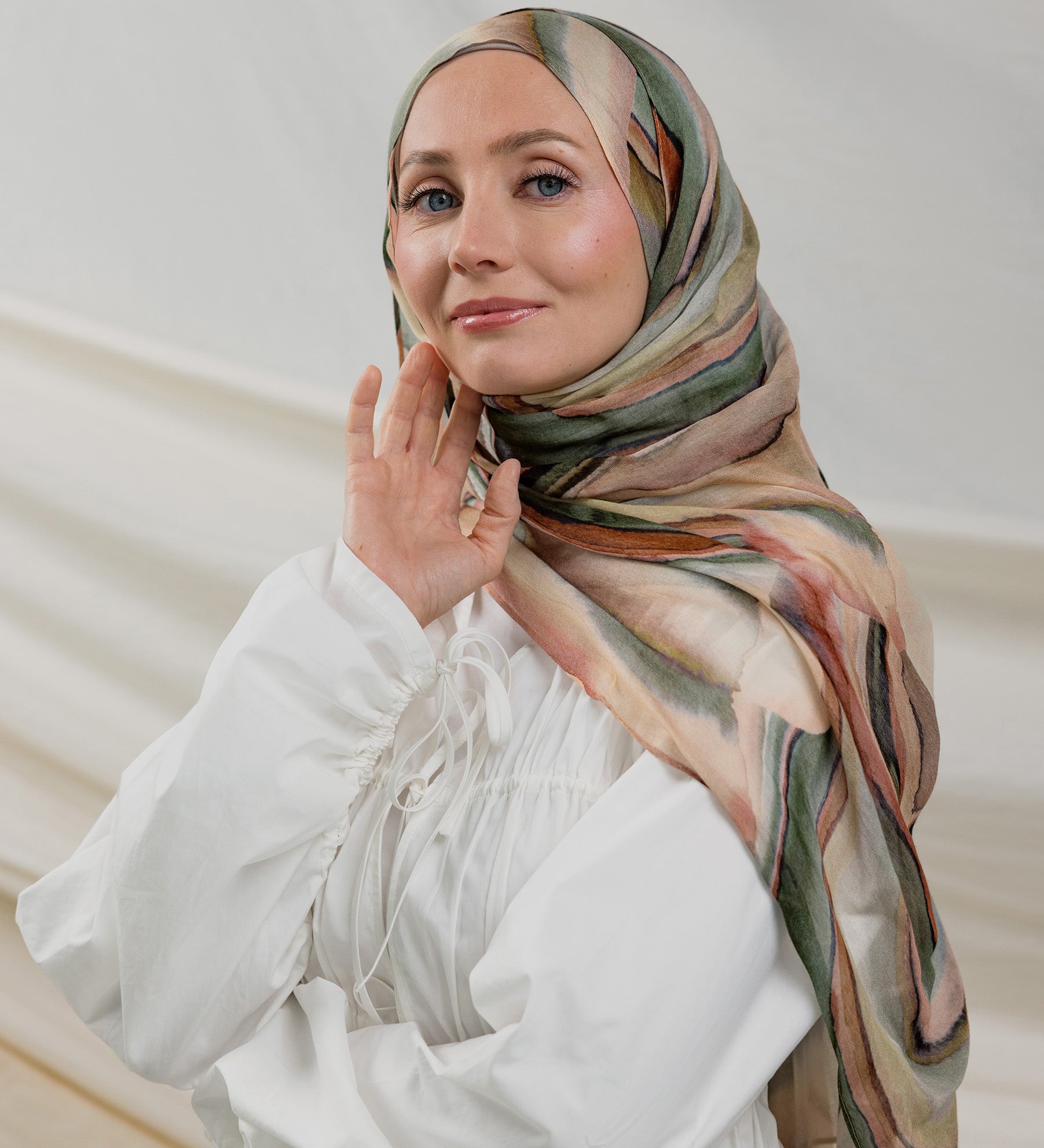 Model wearing modal hijab with a layered sediment-inspired print and artistic detailing.