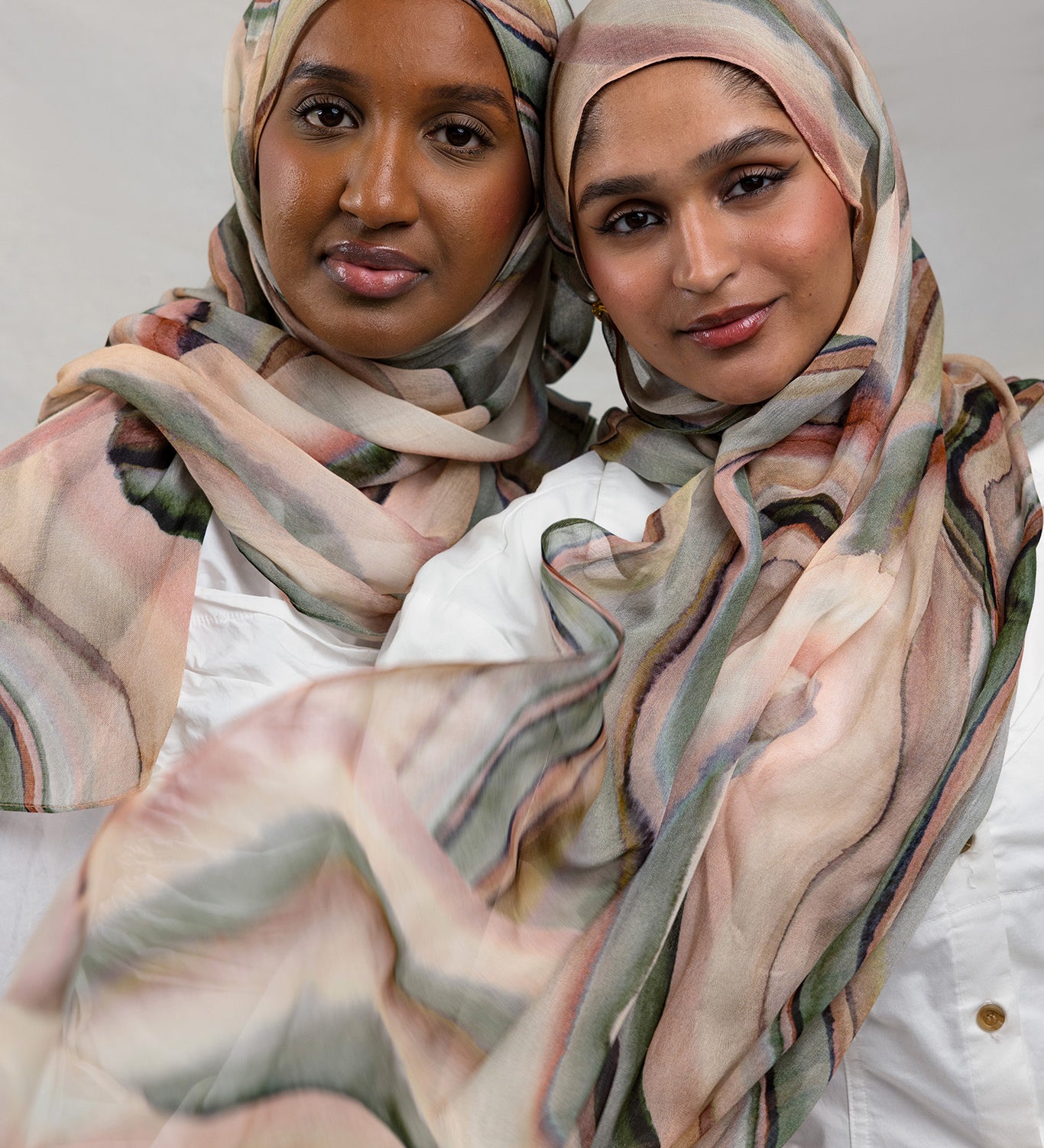 Two Models wearing breathable modal hijab crafted with a vibrant abstract sediment pattern.