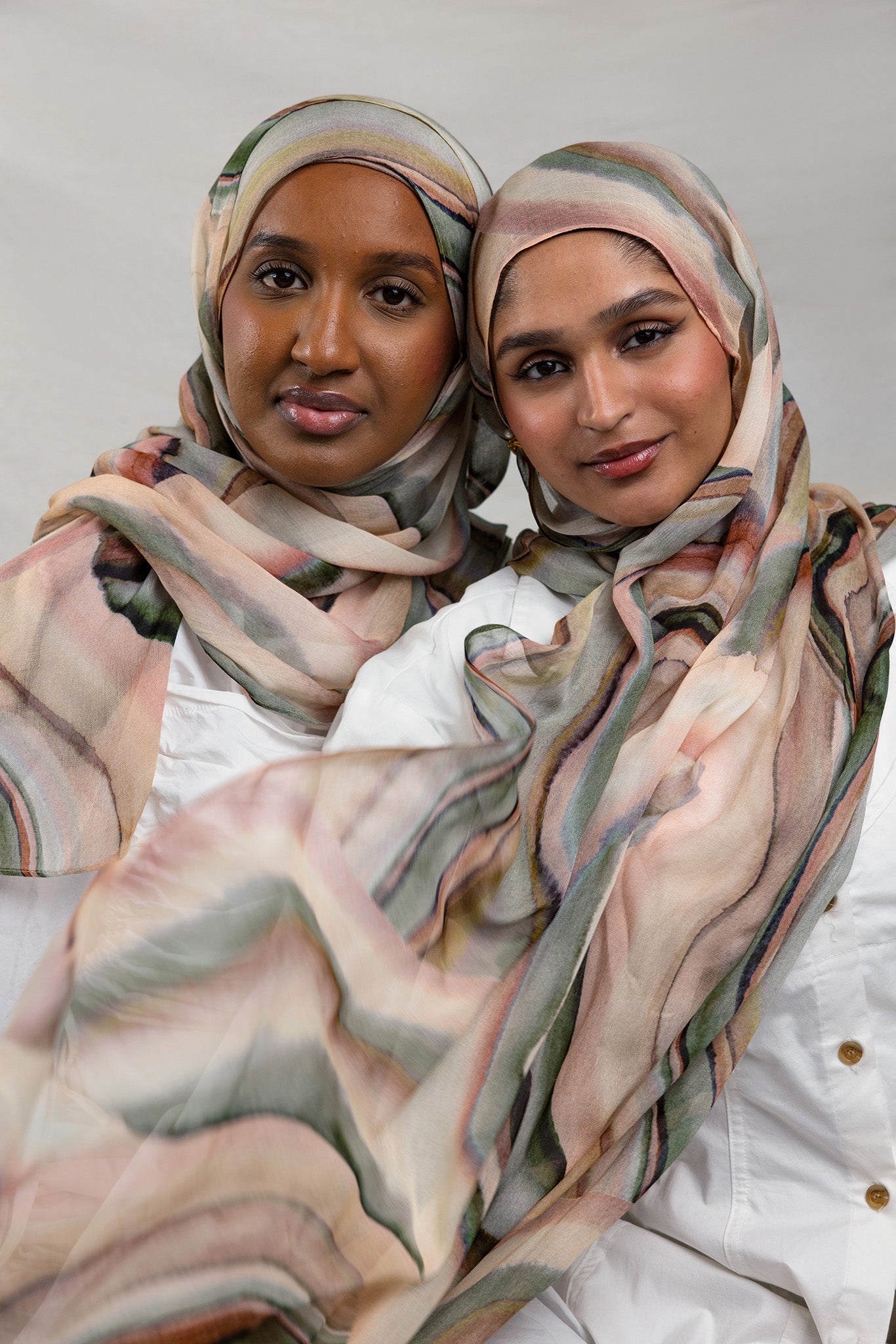 Two Models wearing breathable modal hijab crafted with a vibrant abstract sediment pattern.