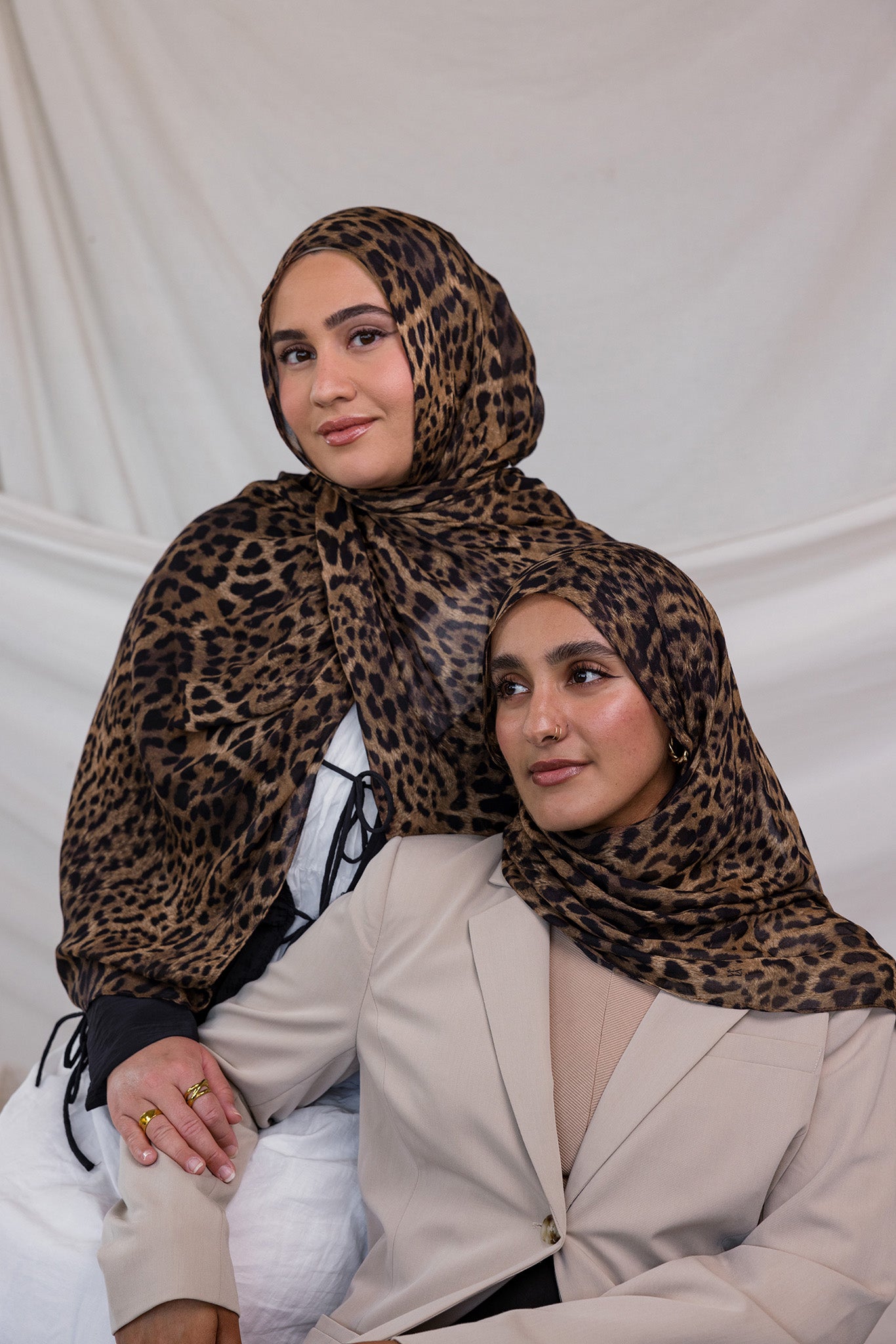 Two models wearing leopard print hijab on modal fabric.