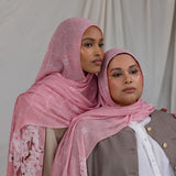 Two models styled in a pink printed hijab featuring cherry blossoms in pink and white.