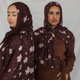 Two models styled in a brown printed hijab with pink and white cherry blossoms.