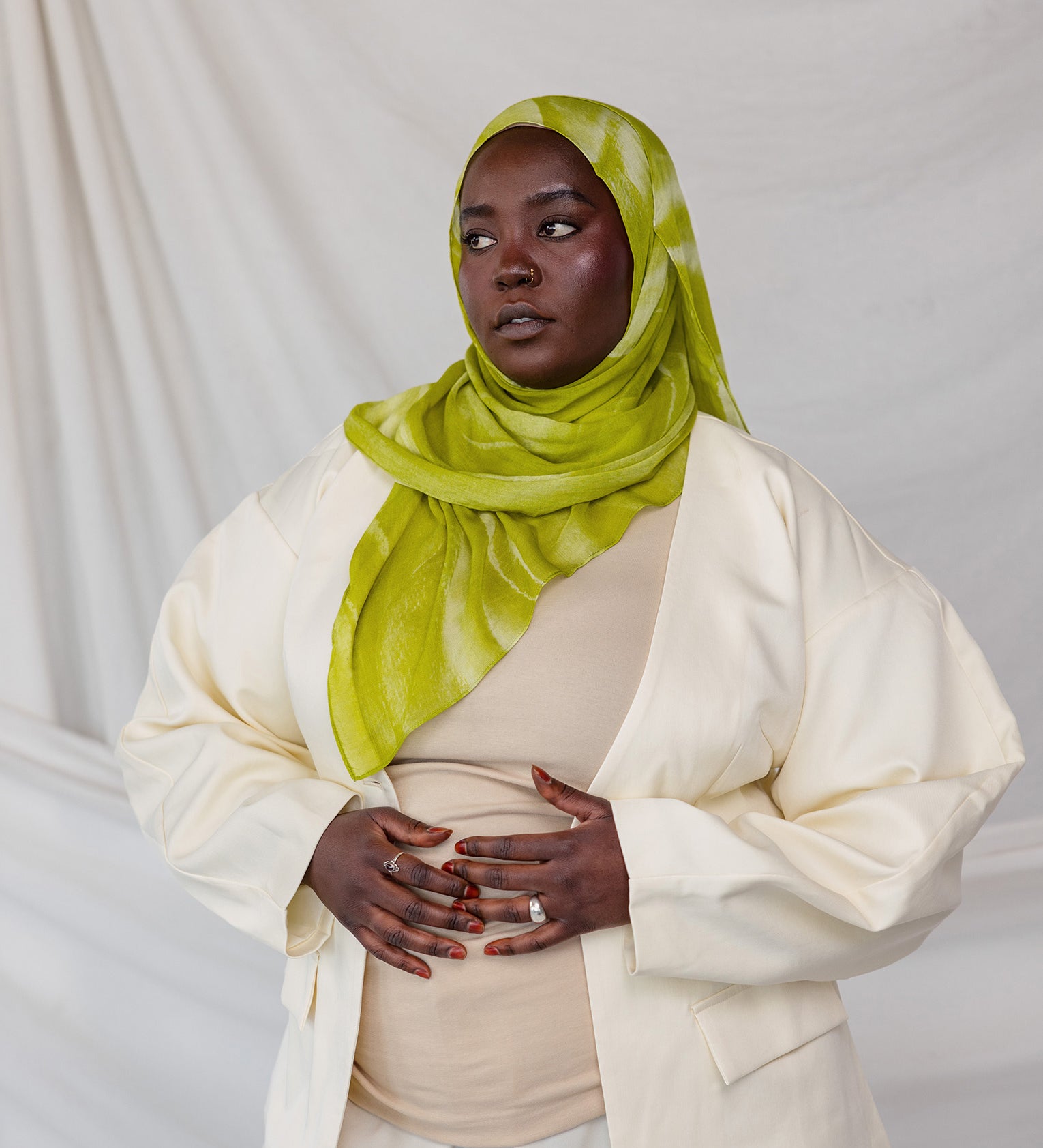 Model styled in a lime green sediment printed hijab and white outfit against a plain background
