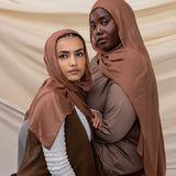 Two models wearing Toasted Pecan hijab against backdrop.
