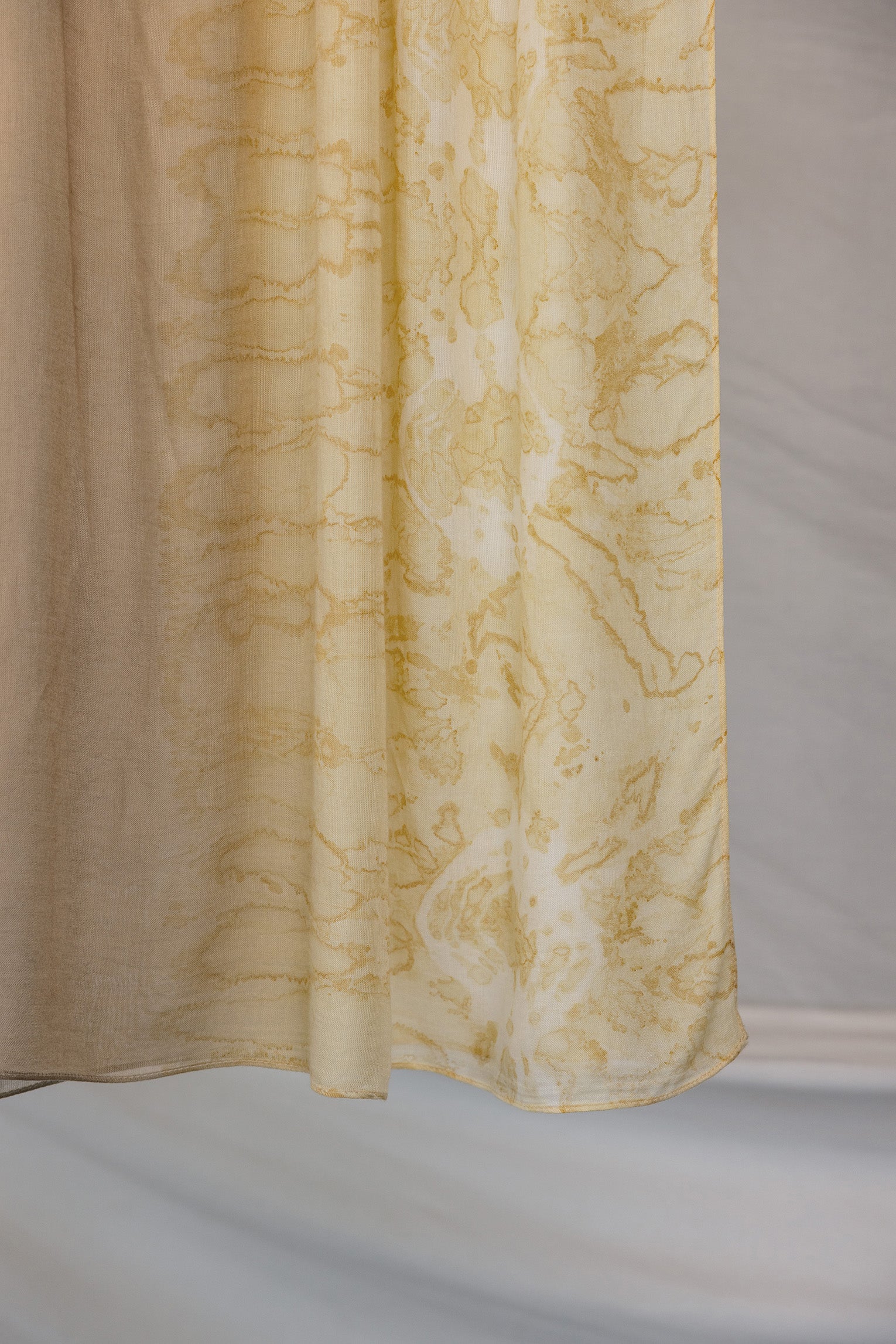 Brown beige hijab with yellow abstract pattern on a plain background