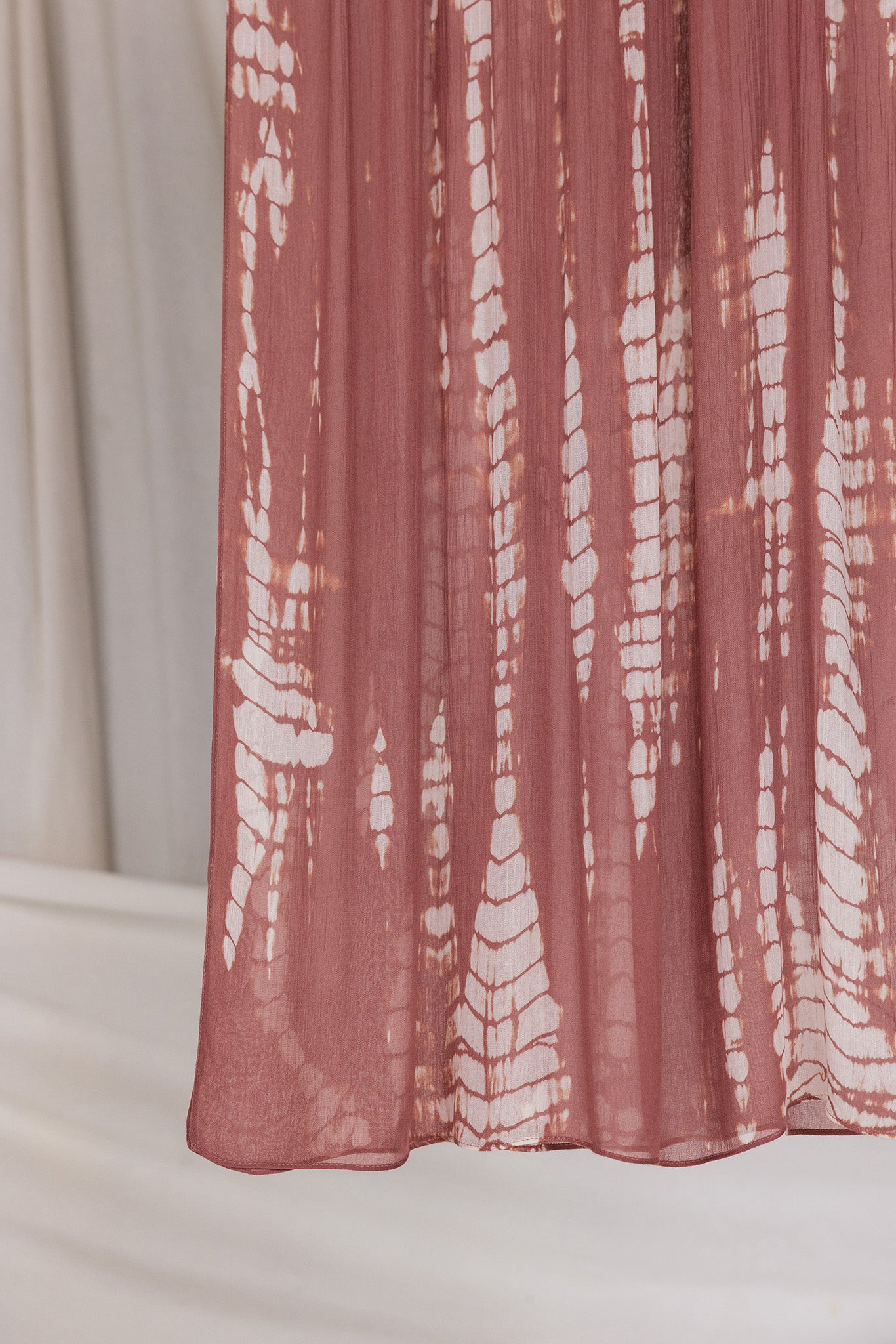 Pink ripple printed hijab draped in front of a neutral background
