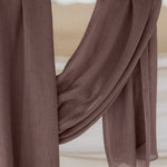 Taupe hijab draped in front of backdrop.