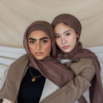 Two individuals wearing taupe-colored hijabs.