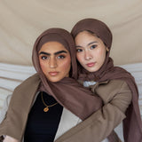 Two individuals wearing taupe-colored hijabs.