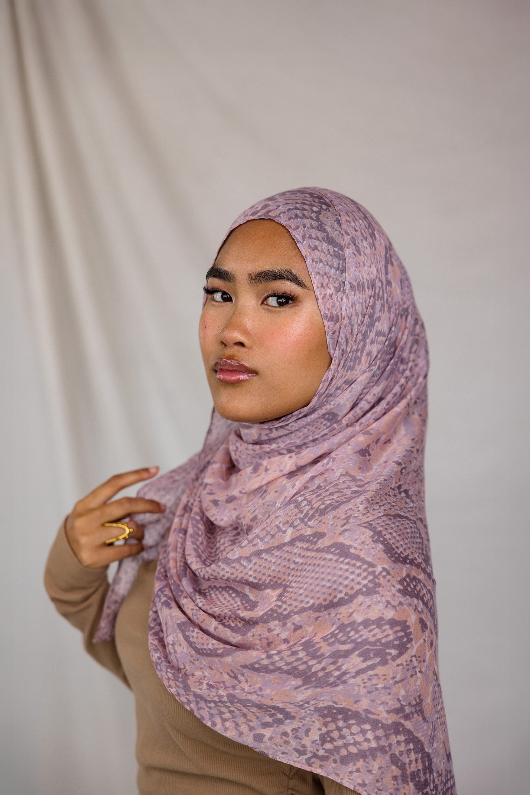 Close up of model in pink and purple snakeskin inspired print. Shows pattern of the hijab.