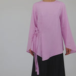 Lightweight modest top with a simple tie-front and natural fabric texture.