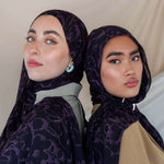 Modal hijab with abstract floral accents and a softly dramatic finish.