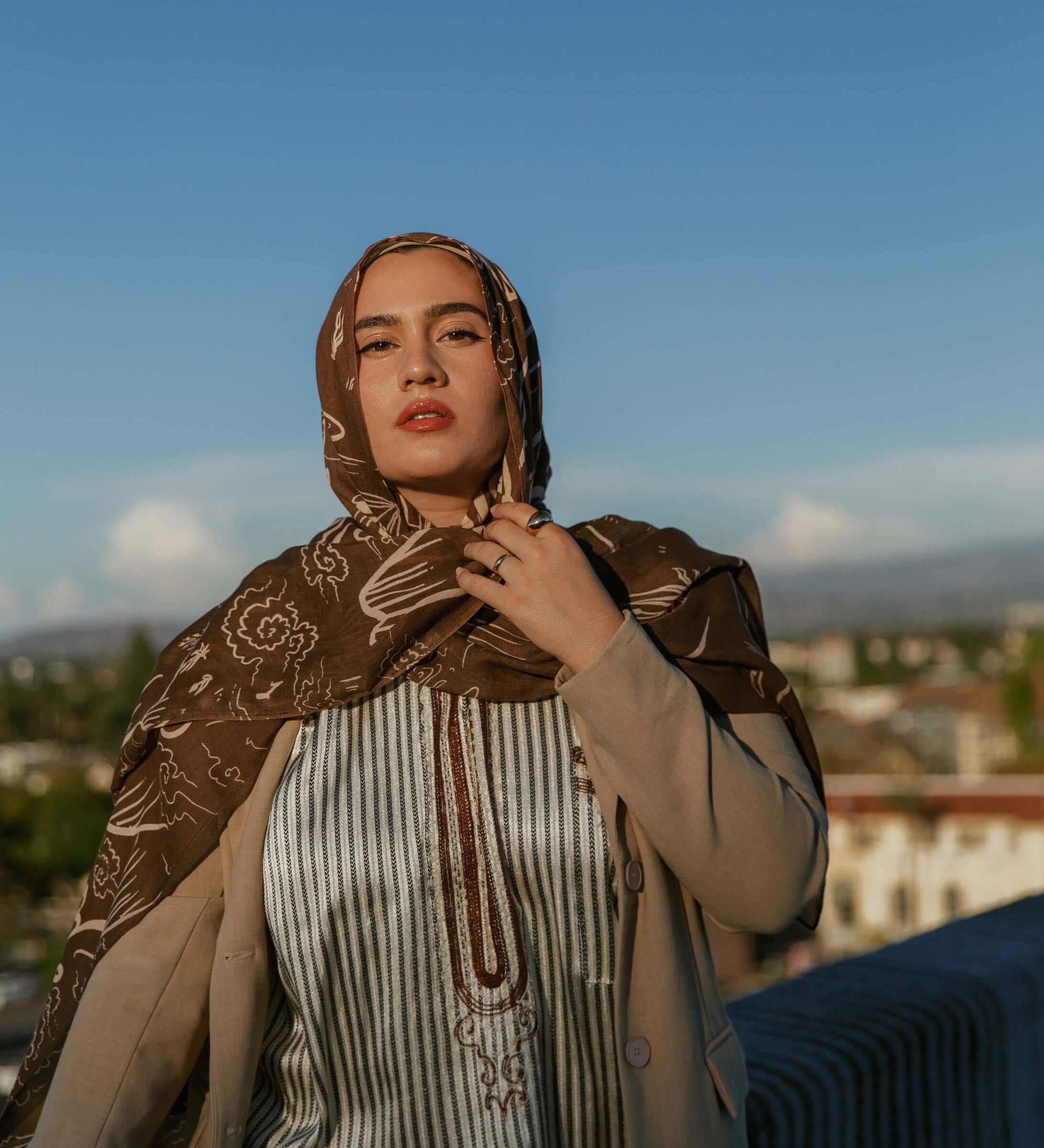 Printed modal hijab with curving Arabic script inspired by themes of home and identity.