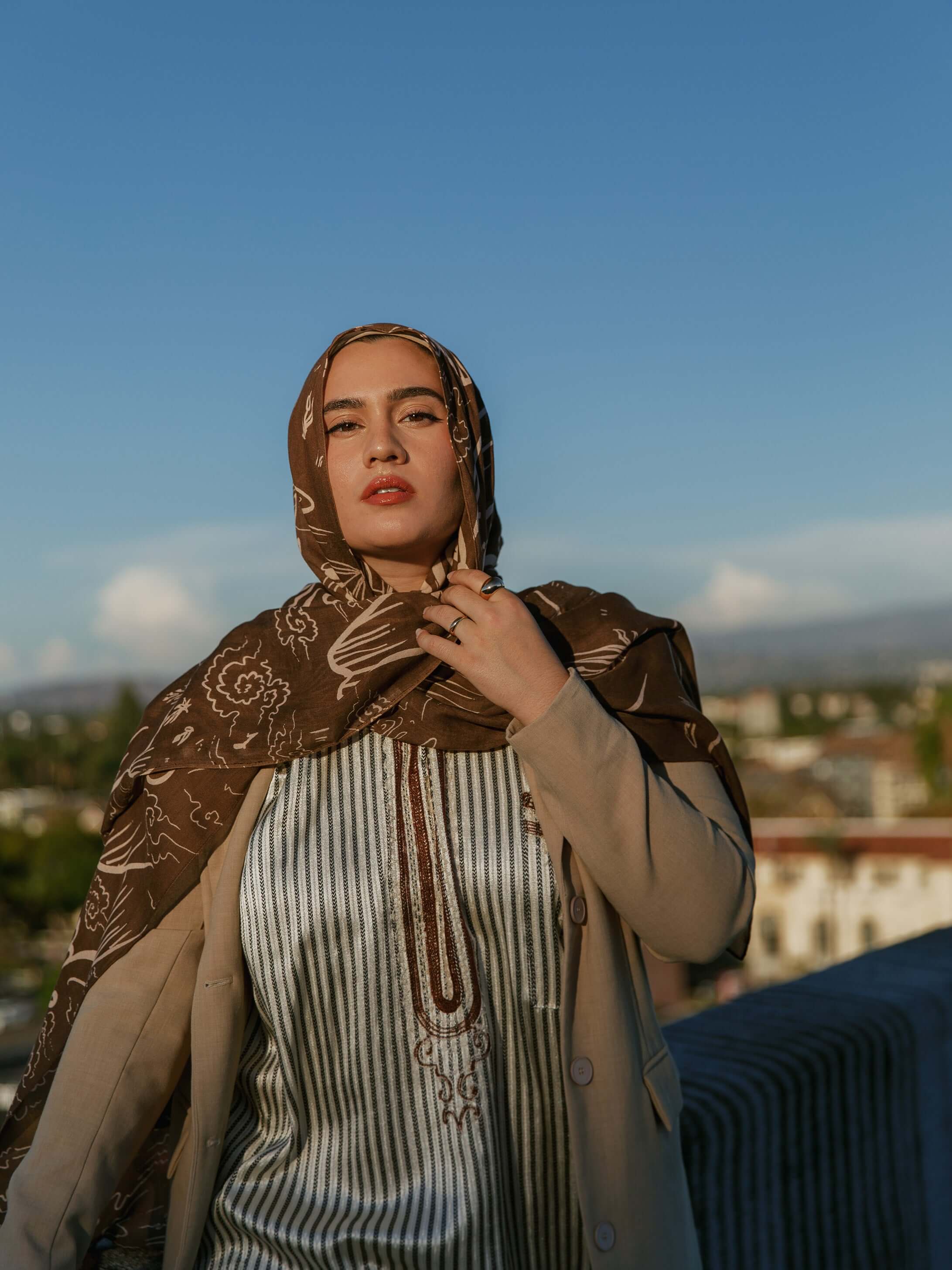 Printed modal hijab with curving Arabic script inspired by themes of home and identity.