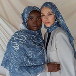 Artist collaboration hijab with poetic Arabic script and gentle fabric drape.