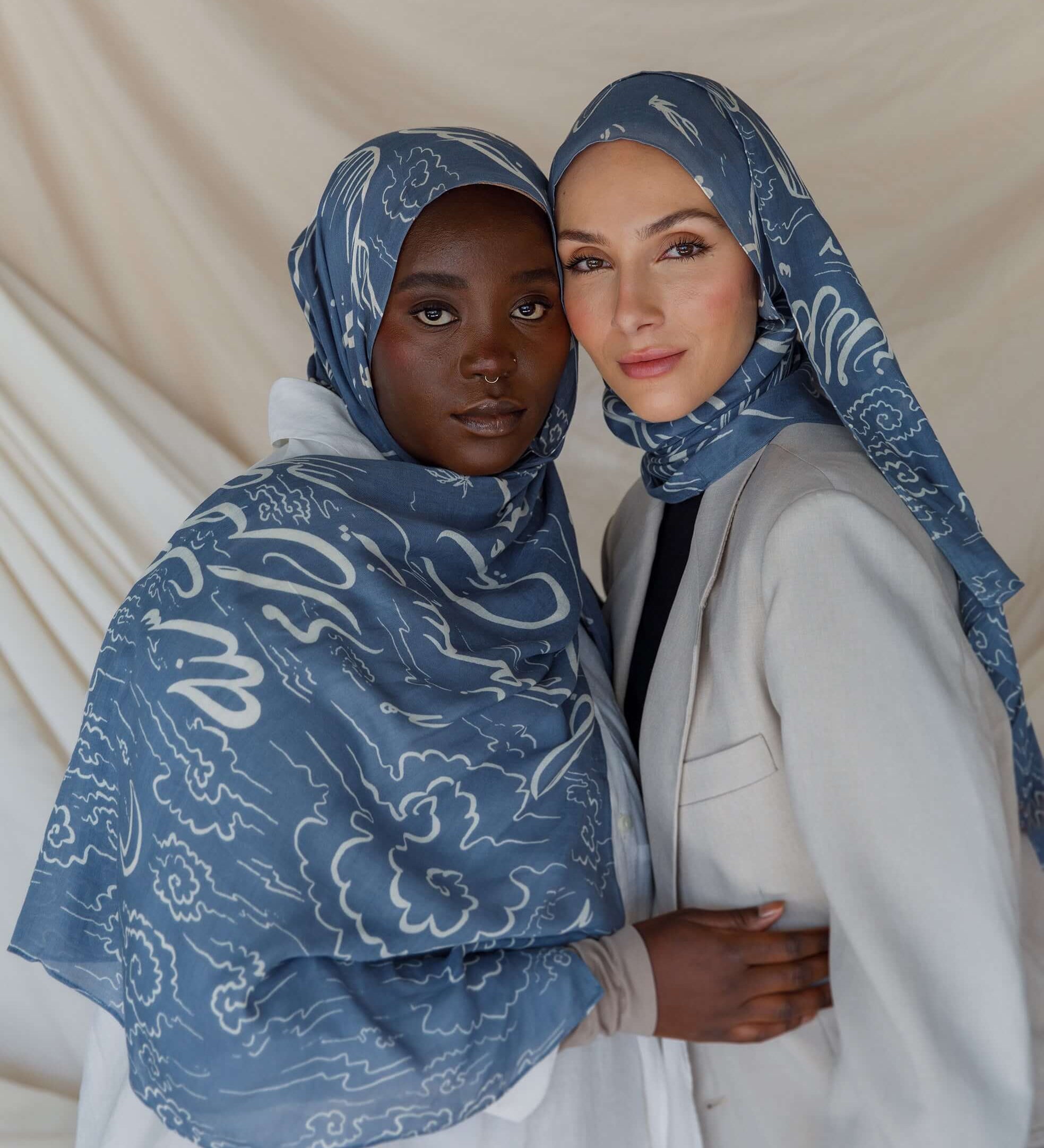 Artist collaboration hijab with poetic Arabic script and gentle fabric drape.