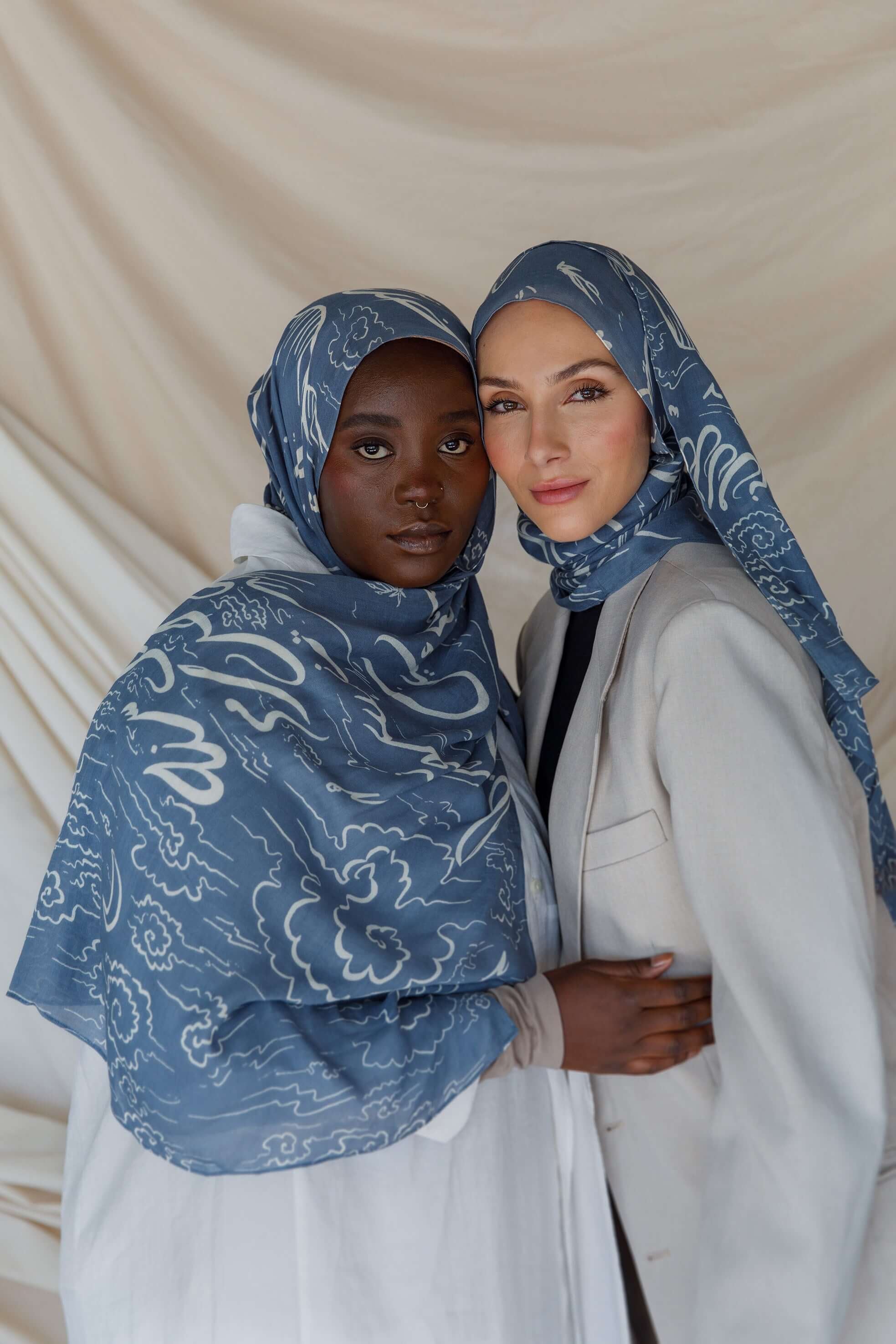 Artist collaboration hijab with poetic Arabic script and gentle fabric drape.