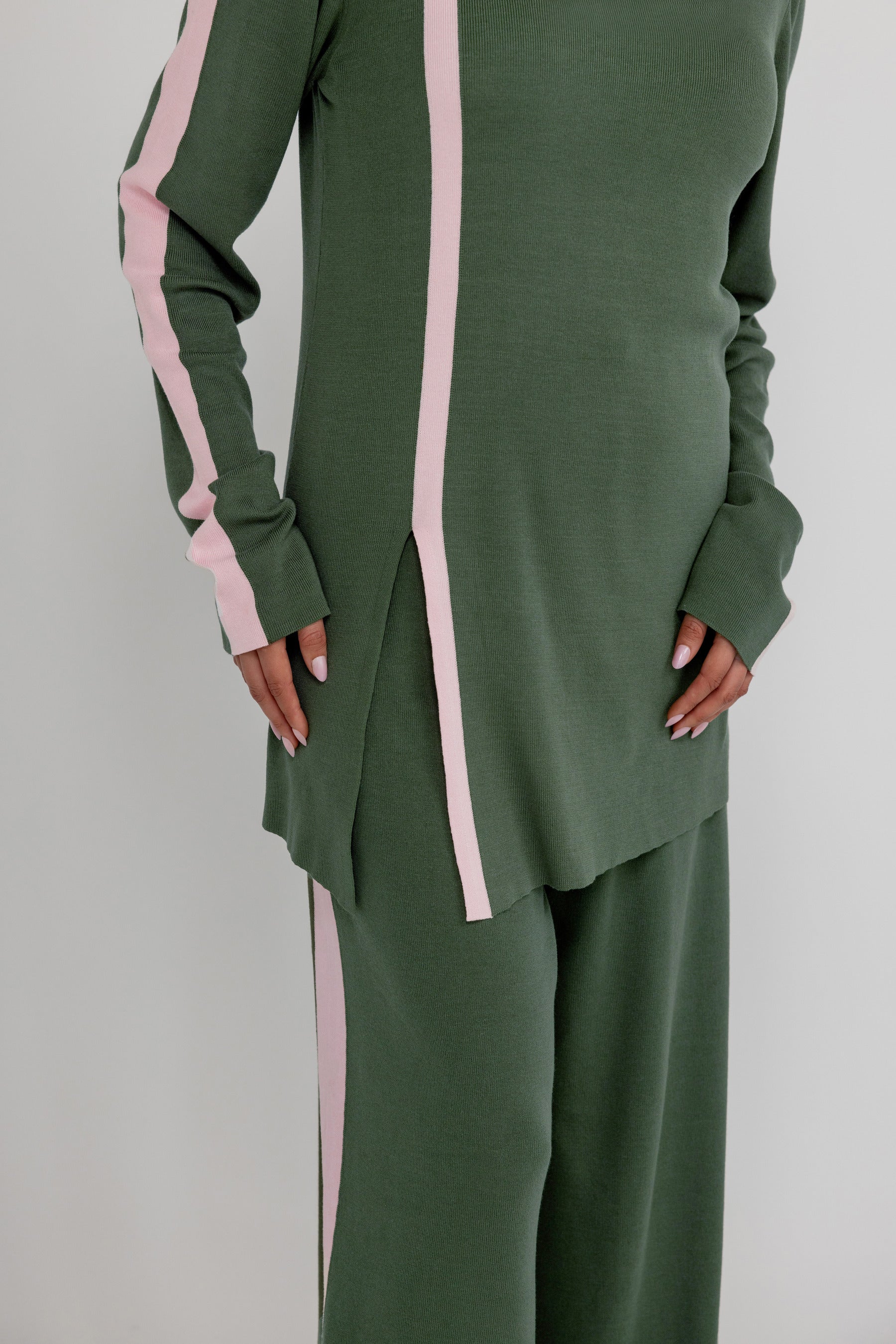 Green matching outfit set with pink stripes on a plain background