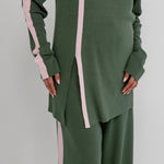 Green outfit with pink stripes on a plain background