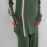 Green outfit with pink stripes on a plain background
