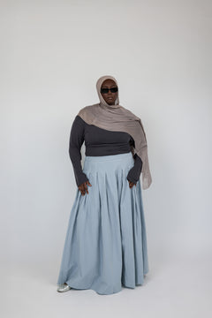 Full-length cotton skirt with wide pleats and a structured, flowing shape.