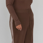 Brown long-sleeve top and wide-leg pants on a plain background