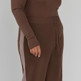 Brown long-sleeve top and wide-leg pants on a plain background