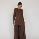 Person wearing a brown outfit on a white background