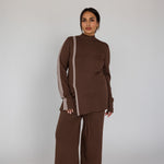 Woman wearing a brown outfit with a white background