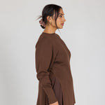 Woman wearing a brown outfit against a white background