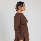 Woman wearing a brown outfit against a white background