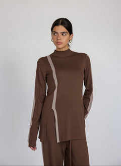 Woman wearing a brown outfit with truffle stripe against a plain background