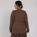 Person wearing a brown outfit against a white background