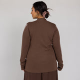 Person wearing a brown outfit against a white background
