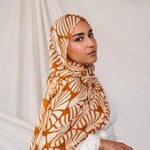 Woman wearing Amber Shells printed hijab against a plain background