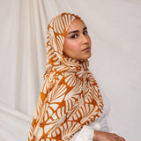 Woman wearing Amber Shells printed hijab against a plain background