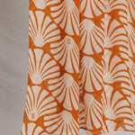 Fabric with orange shell pattern against a plain background