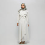 Woman wearing a white dress with a belt and a gray hijab on a white background