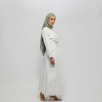 Woman wearing a white dress and gray hijab on a white background