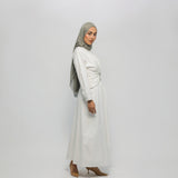 Woman wearing a white dress and gray hijab on a white background