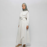 Woman wearing a white outfit with a belt and a gray hijab on a white background