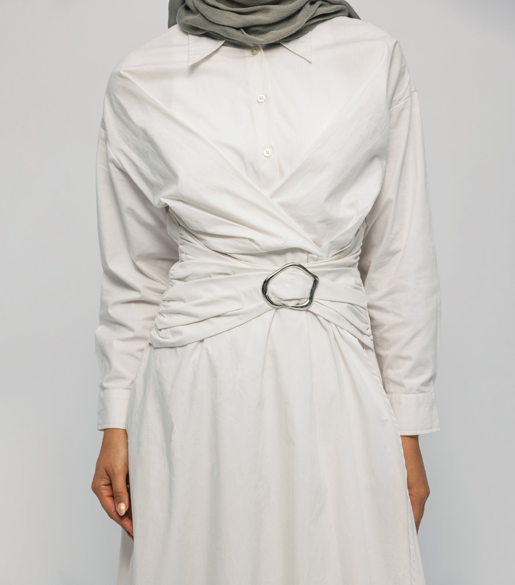 White dress with a belt and hijab on a plain background