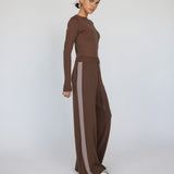 Woman wearing a brown outfit with wide-leg pants on a white background