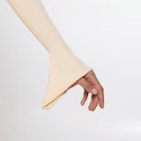 A close-up of a hand wearing a cream-colored ribbed knit sleeve with a flared cuff, set against a plain white background.