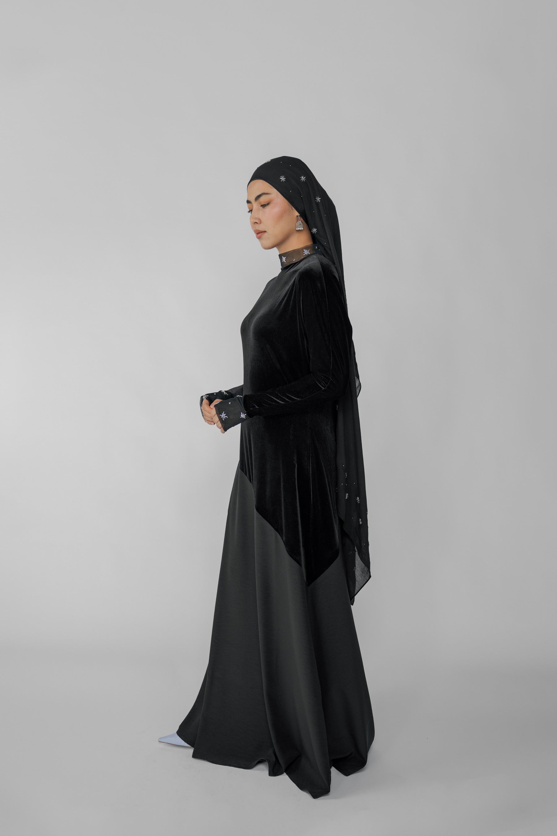 Woman wearing a black dress on a gray background