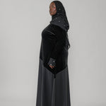 Woman wearing a black dress with a hood on a white background